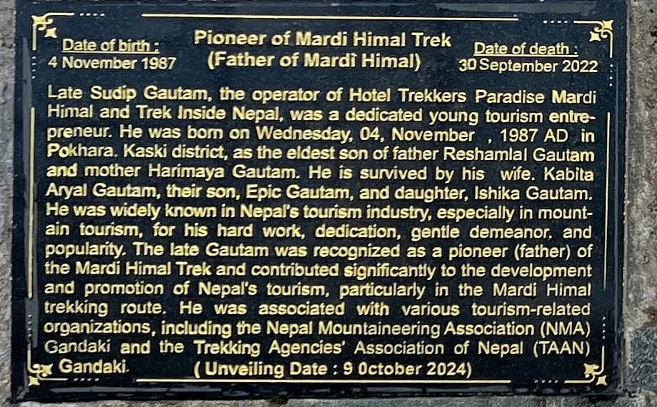 Brass-lettered memorial plaque giving Sudip Gautam's dates of birth and death and titling him Pioneer of Mardi Himal Trek, Father of Mardi Himal